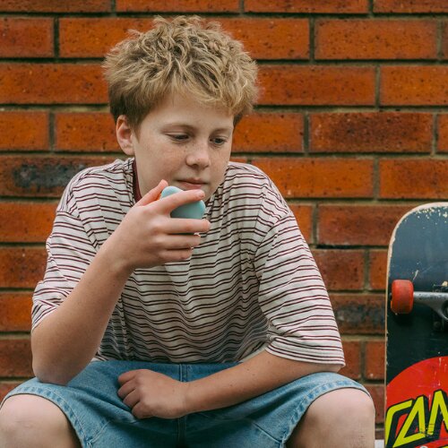Boy with his skateboard talking on a Waffle Go kids phone